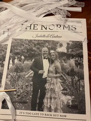 Front page of The Norms wedding newspaper for Isabelle and Andrew with lace ribbon wands
